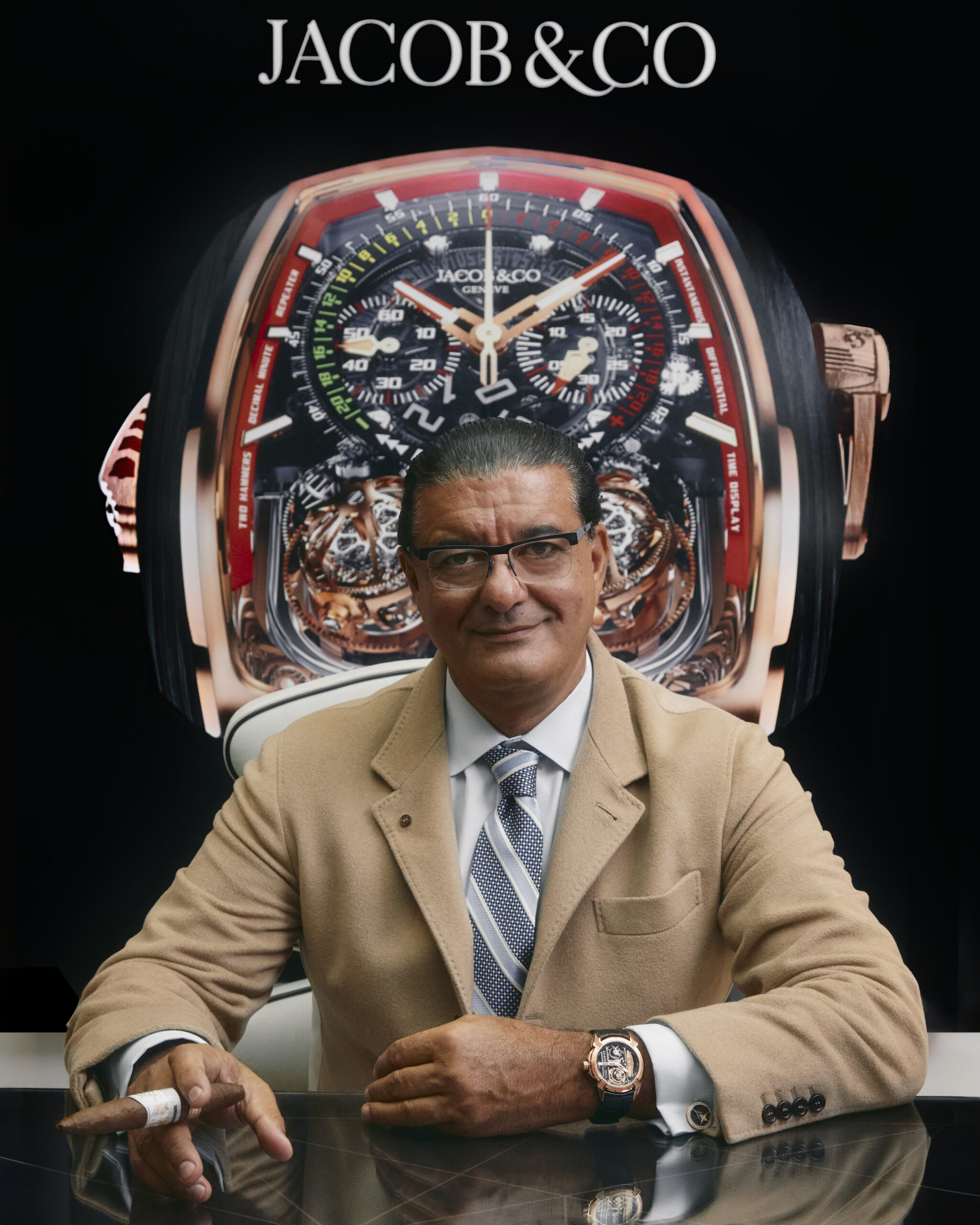La Aurora Partners with Jacob & Co. Watch Company man holding cigar with large watch in the background